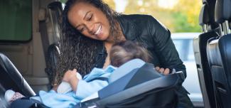 woman buckling child into carseat